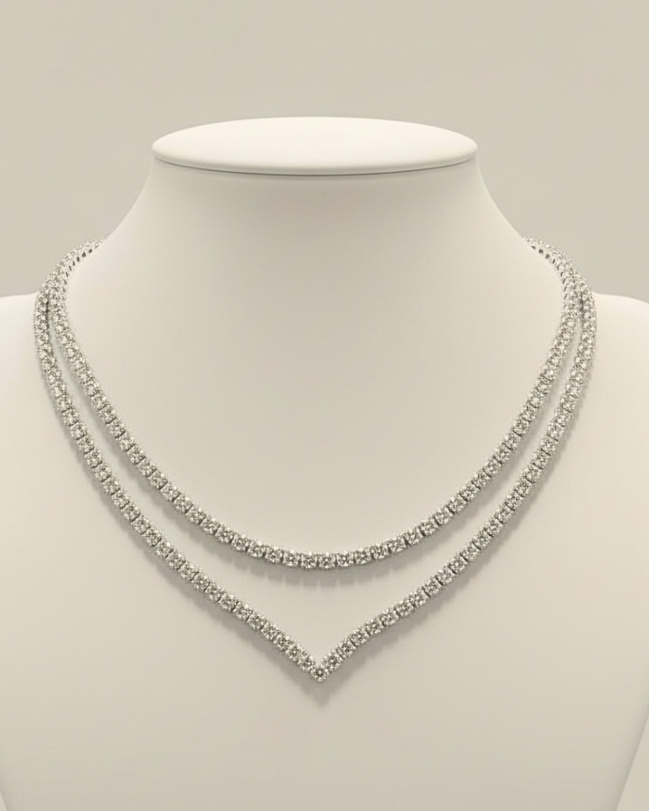 Dettaglio della collana tennis a V ÉCLAT in argento che cattura la luce naturale sul décolleté