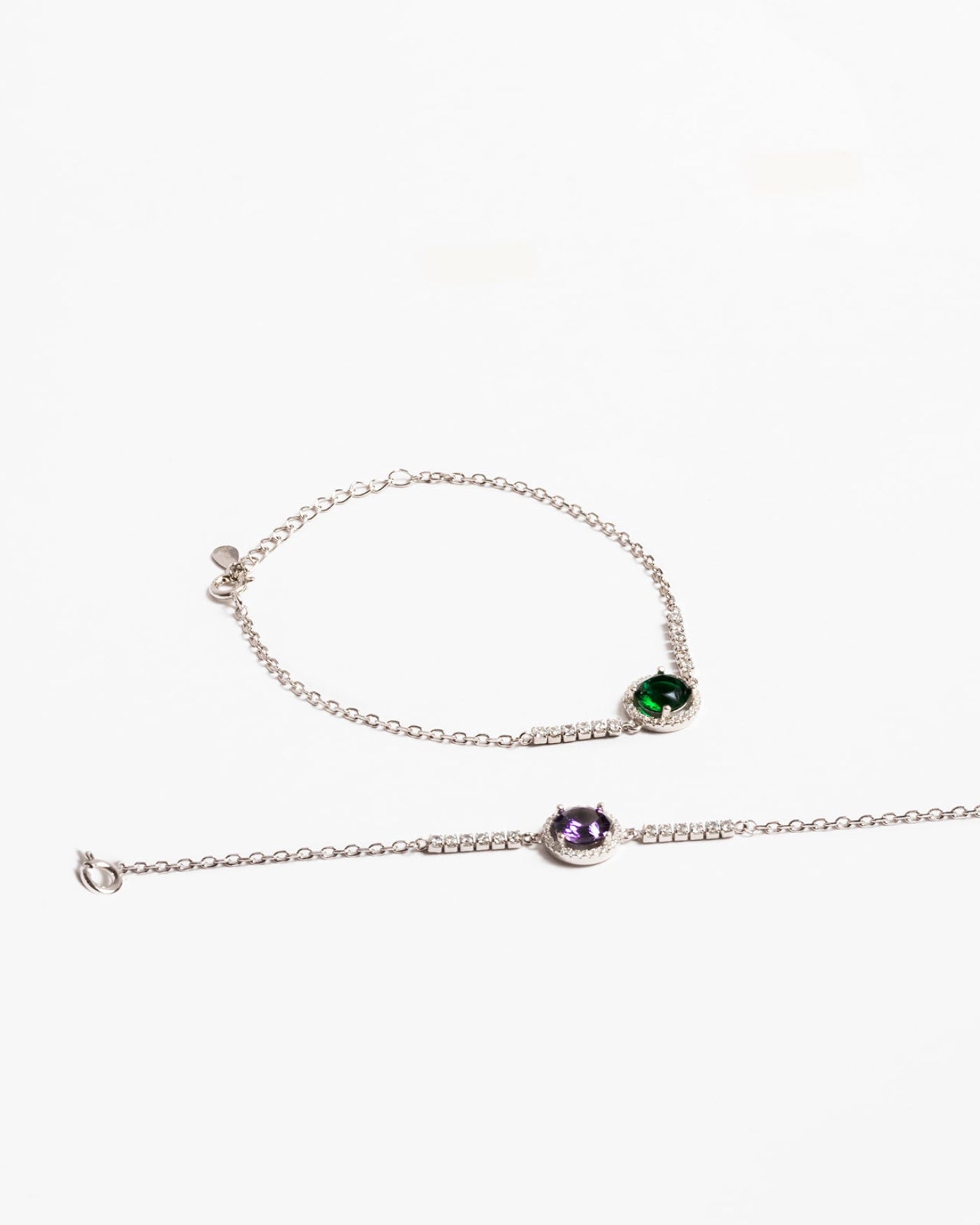 Élégant bracelet en argent 925 avec une pierre précieuse colorée et l'autre une pierre précieuse violette, ornée d'un délicat accent de zircone cubique, présentant un design minimaliste et moderne.