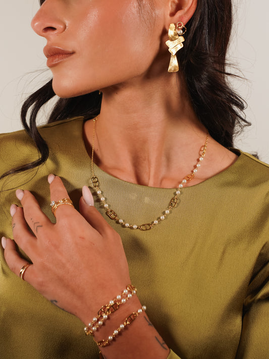 dettaglio texture finitura satinata orecchini nodo oro indossata da una modella