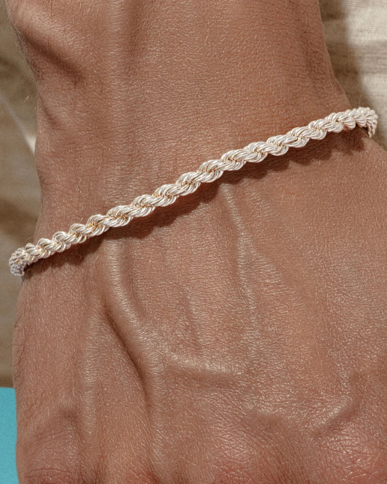 "Bracciale da uomo modello fune in Argento 925 indossato su polso maschile. Look casual ed elegante con camicia in lino, ideale per uno stile minimalista firmato Éclat Gioielli."