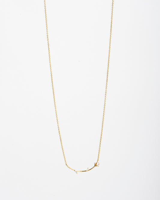 Collana Akoya Branch in argento 925 placcato oro con pendente a ramoscello, perla e zirconi bianchi su sfondo bianco - Eclat Gioielli."