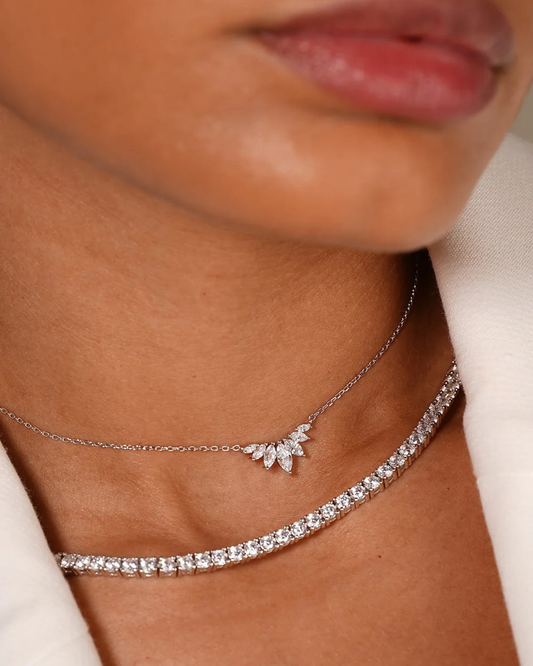 "Dettaglio layering di collane Éclat Gioielli: Collier Tennis classico in argento e zirconi abbinato a una collana sottile con pendente a ventaglio di pietre taglio marquise. Un look di lusso contemporaneo."