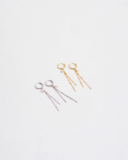 Due paia di orecchini pendenti in argento sterling 925, uno color argento e uno placcato oro, entrambi con catenine e perle, disposti su sfondo bianco."