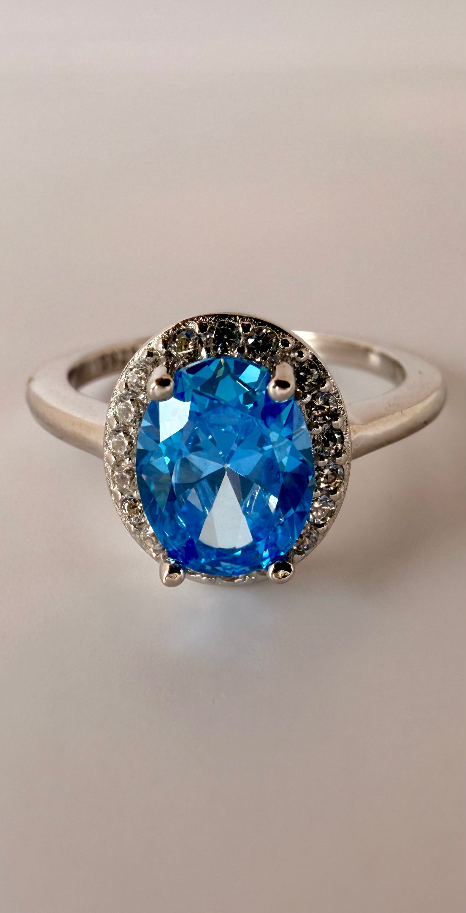elegant sterling silver ring featuring a vibrant blue cushion-cut gemstone and clear halo accents by eclat gioielli