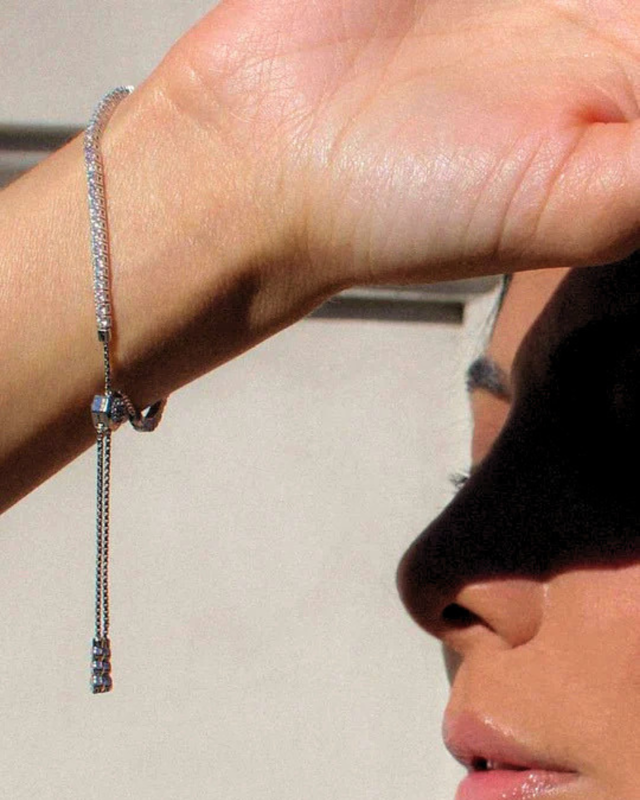 Bracciale tennis regolabile in argento 925 con zirconi indossato sul polso da una donna.