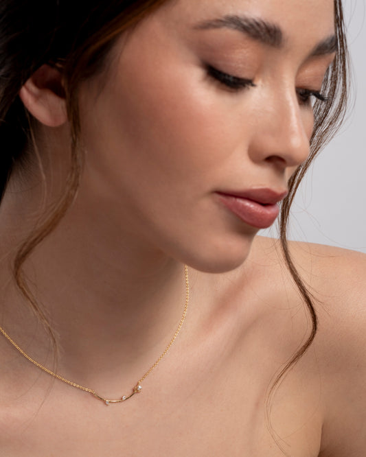 Modella che indossa la collana Akoya Branch di Eclat Gioielli: esempio di indosso di un gioiello minimalista ispirato alla natura in argento placcato oro."